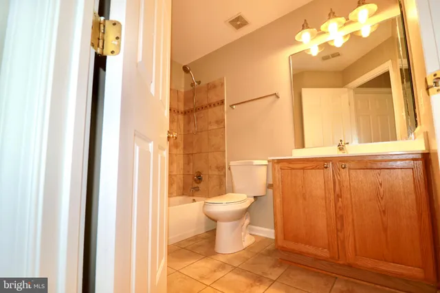 a bathroom with a granite countertop toilet and a sink