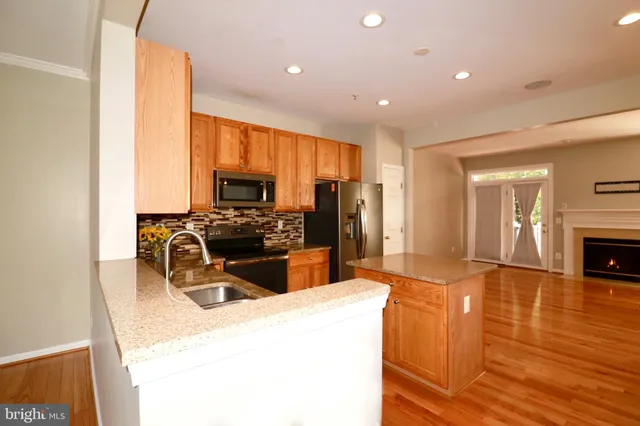 a kitchen with stainless steel appliances granite countertop a refrigerator a stove top oven a sink and dishwasher