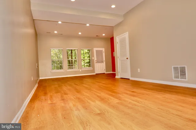 a view of an empty room with a window and a bathroom