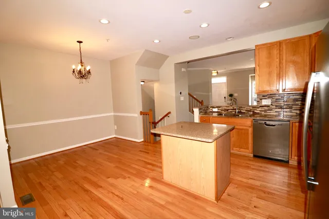 a kitchen with stainless steel appliances granite countertop a sink a stove and a refrigerator