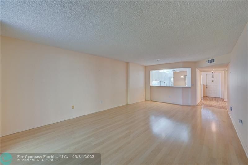 9599 Weldon Circle, Unit A101 Tamarac, FL 33321 - Photo 11 of 28 a view of an empty room with wooden floor and a window