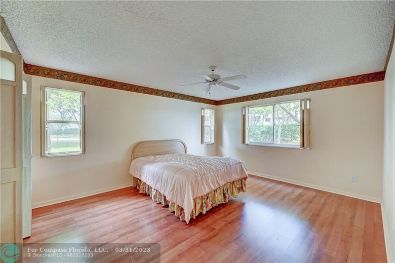 9599 Weldon Circle, Unit A101 Tamarac, FL 33321 - Photo 18 of 28 a bedroom with a bed lamp and window