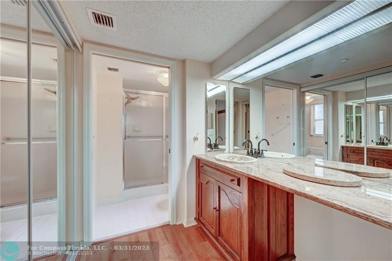9599 Weldon Circle, Unit A101 Tamarac, FL 33321 - Photo 22 of 28 a bathroom with a granite countertop sink mirror and double