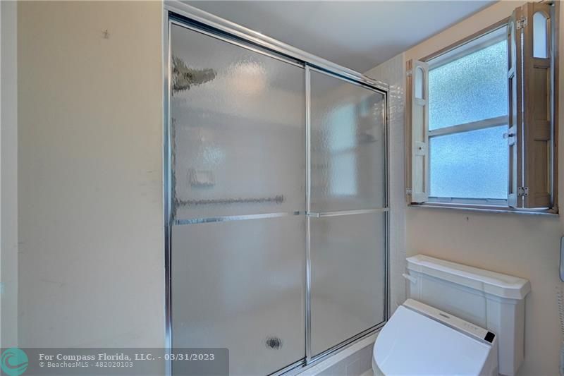 9599 Weldon Circle, Unit A101 Tamarac, FL 33321 - Photo 24 of 28 a bathroom with a shower a toilet and a sink