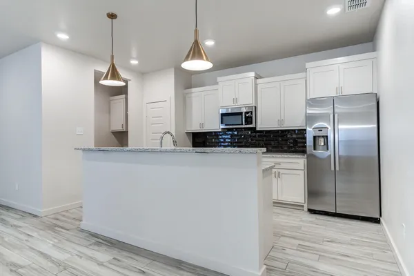 a kitchen with stainless steel appliances a refrigerator sink and microwave