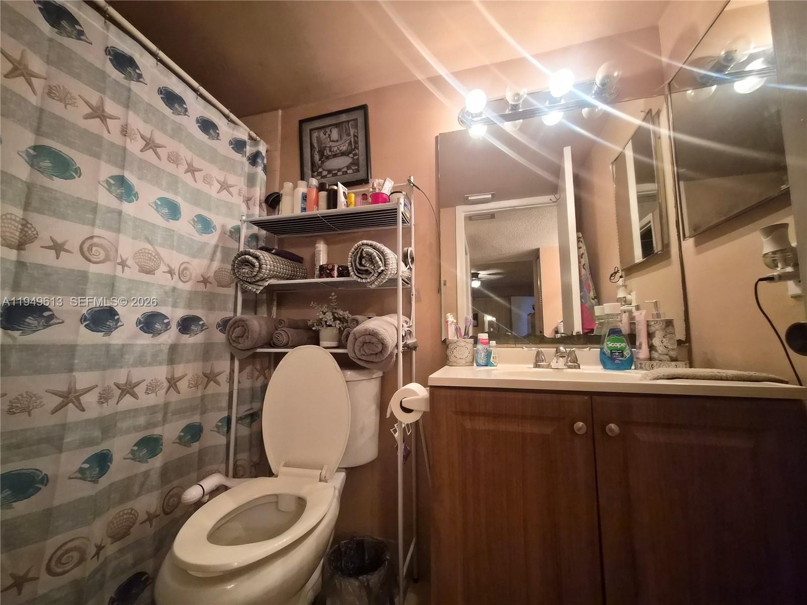 800 Independence Drive, Unit 800F Homestead, FL 33034 - Photo 11 of 26 a bathroom with a sink a toilet and a mirror