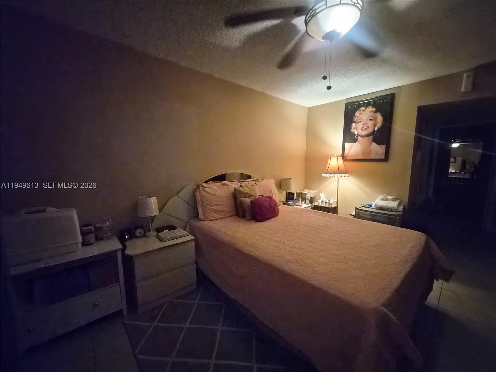 800 Independence Drive, Unit 800F Homestead, FL 33034 - Photo 9 of 26 a bedroom with a bed and lamp on the dresser