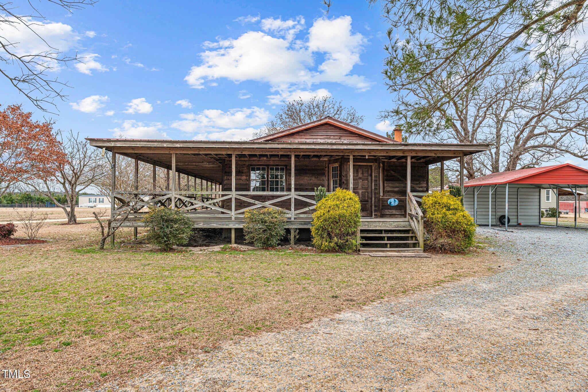 a view of a house with a patio and a yard
