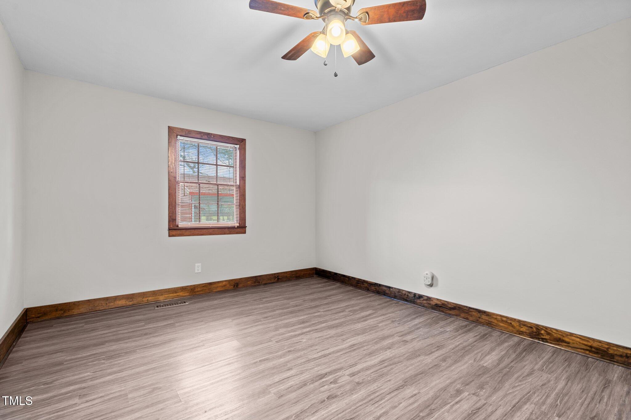 578 Marler Road Benson, NC 27504 - Photo 17 of 55 an empty room with wooden floor chandelier fan and windows