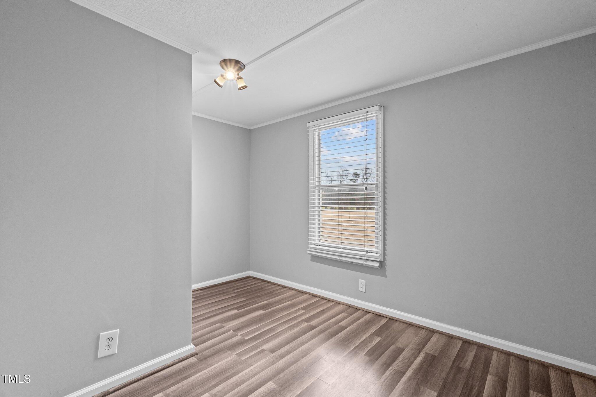 578 Marler Road Benson, NC 27504 - Photo 28 of 55 a view of an empty room with wooden floor and a window