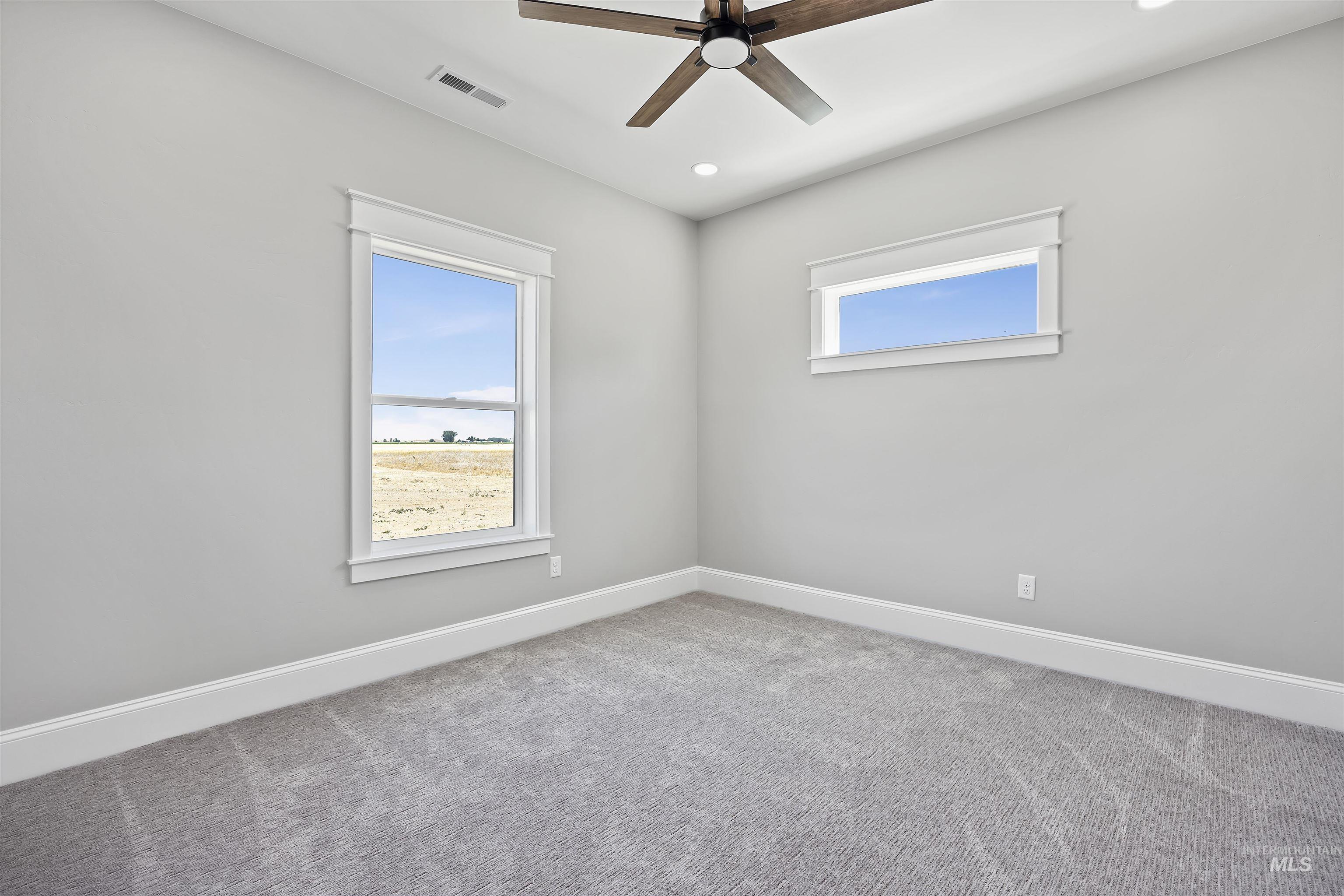 378 West 100 South Rupert, ID 83350 - Photo 35 of 50 Neutral-toned room featuring a large window, a horizontal accent window, and plush gray carpeting