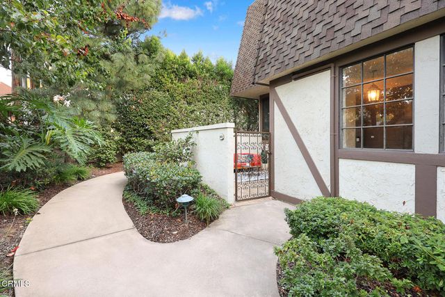 a view of a small house with potted plants