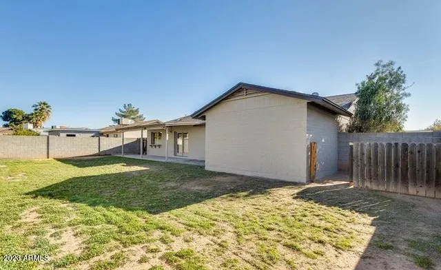 a backyard of a house with table and chairs