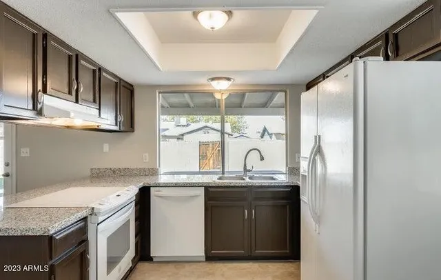 a kitchen with stainless steel appliances granite countertop a sink a stove and a refrigerator