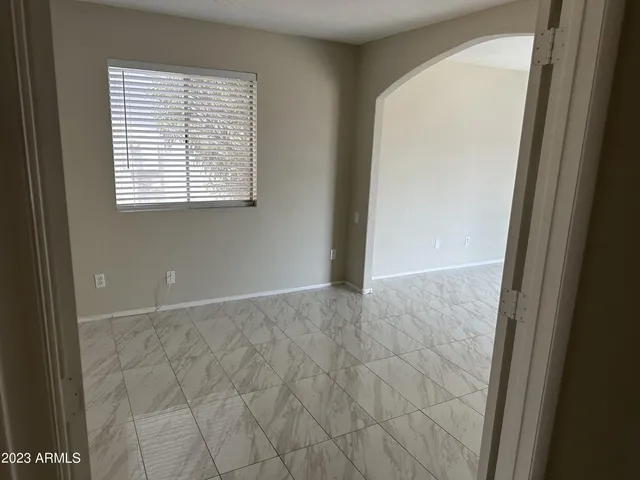 an empty room with a window and a fan