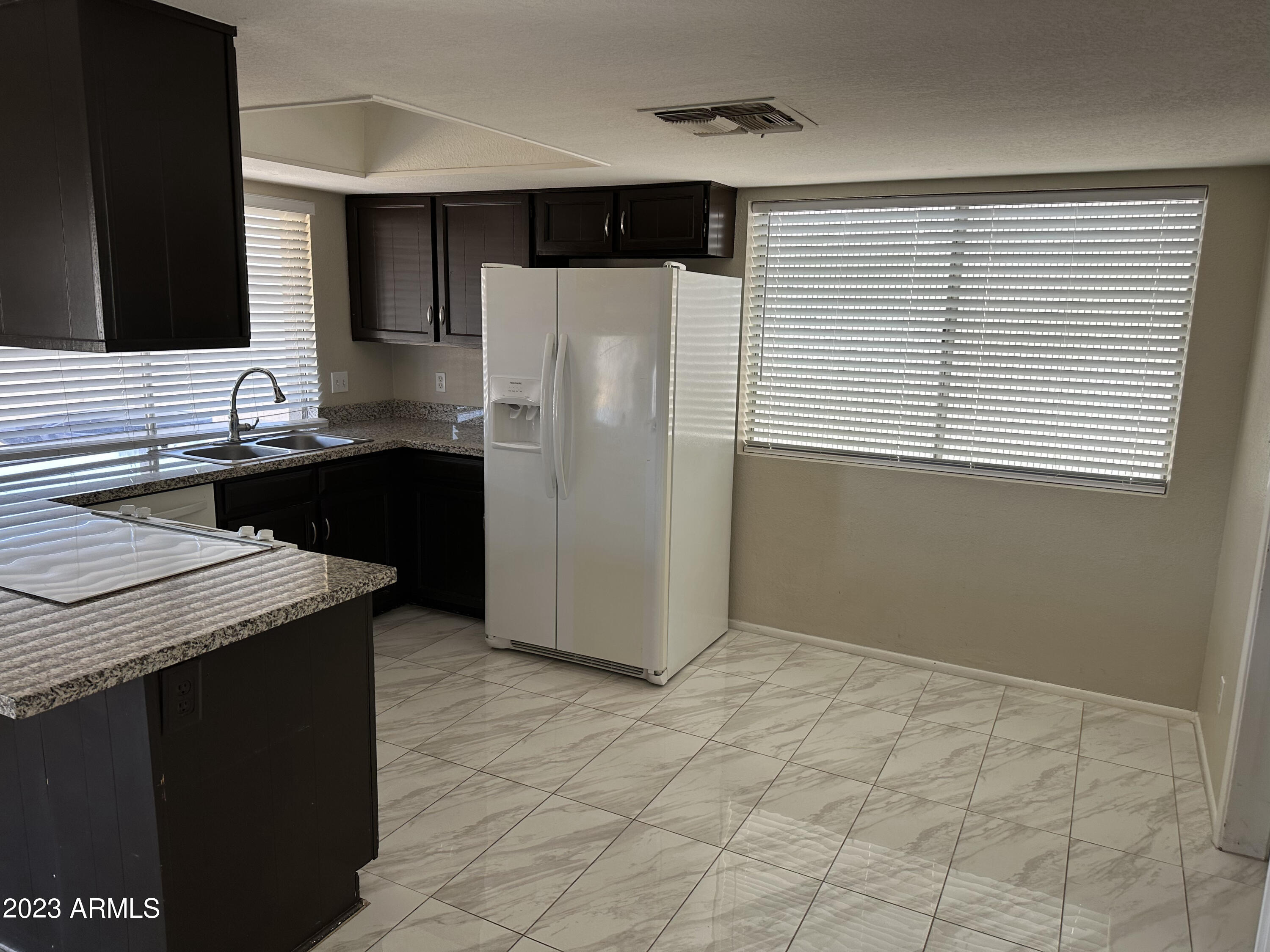 2536 East Commonwealth Circle Chandler, AZ 85225 - Photo 32 of 34 a kitchen with granite countertop a refrigerator and a sink