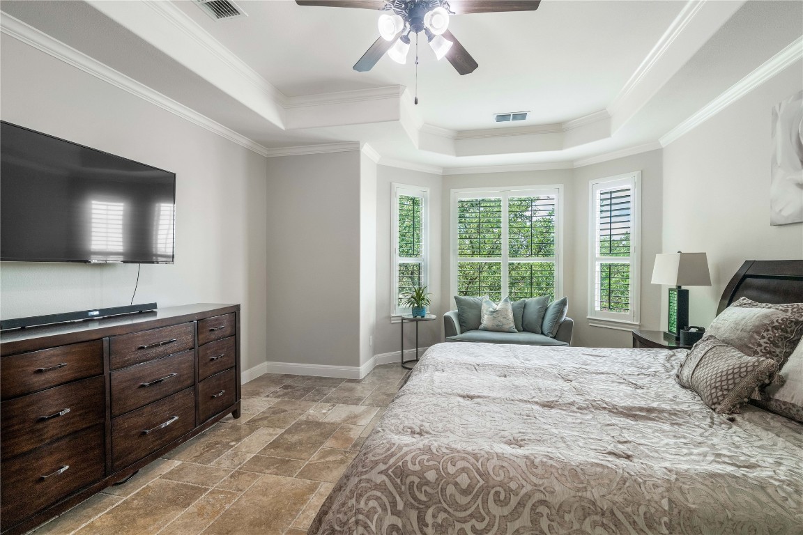13301 Country Trails Lane Austin, TX 78732 - Photo 11 of 40 Primary Bedroom featuring a tray ceiling, stone tile floors, crown molding, and a ceiling fan