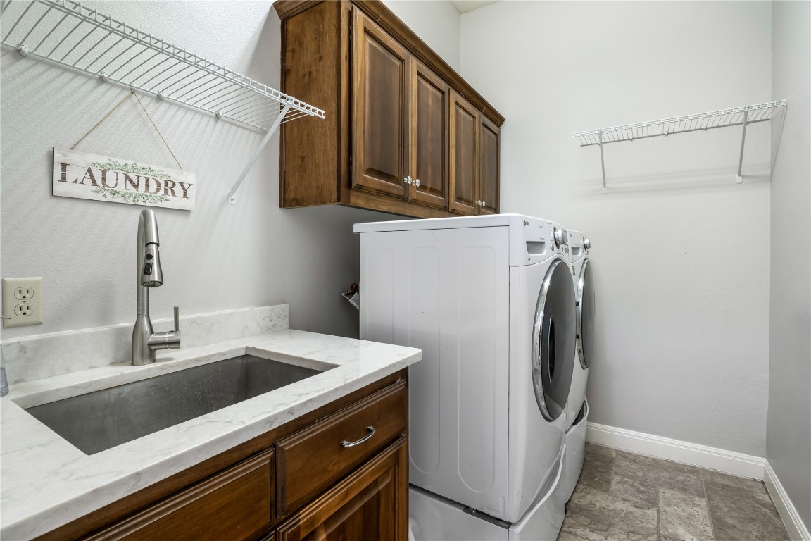 13301 Country Trails Lane Austin, TX 78732 - Photo 21 of 40 Main floor Laundry room with washer/dryer, sink with quartz countertop, and spacious cabinet space