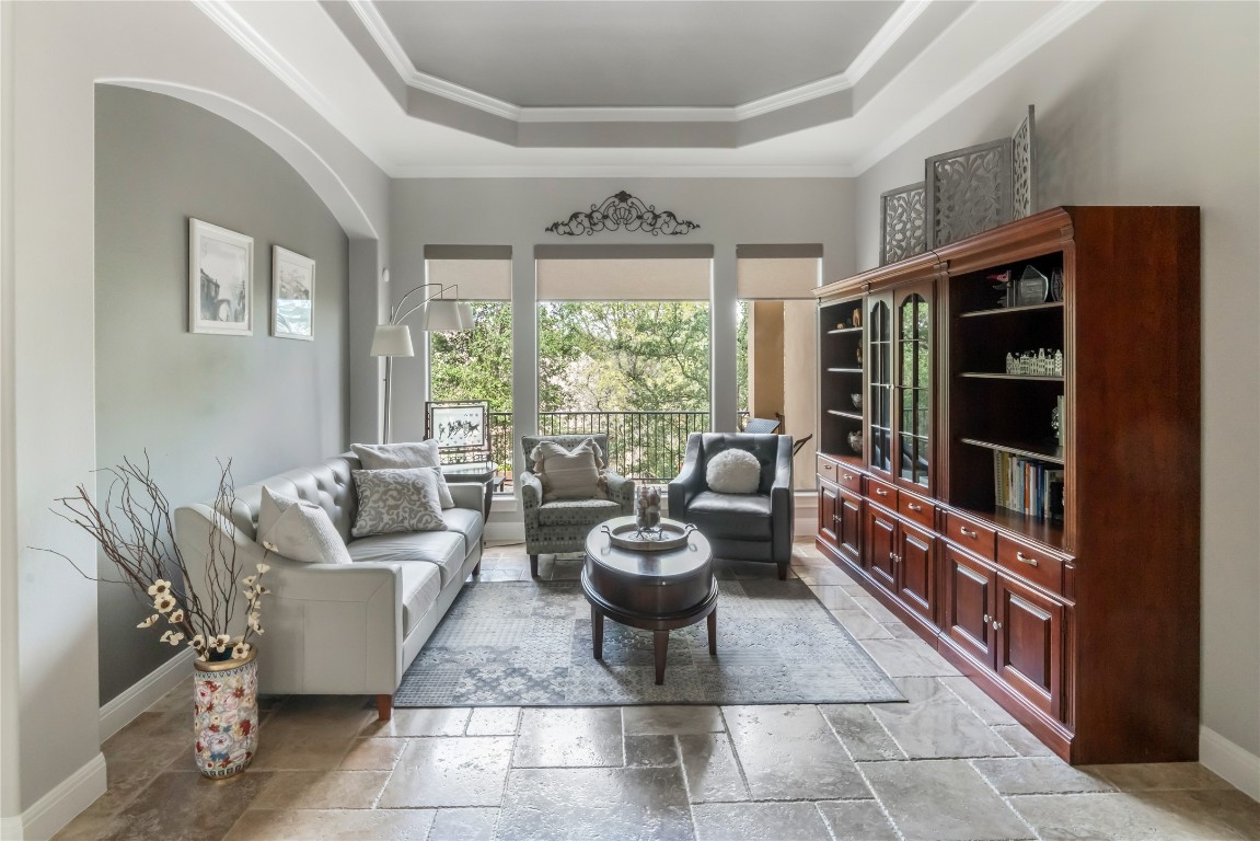 13301 Country Trails Lane Austin, TX 78732 - Photo 10 of 40 Living room with a tray ceiling, stone tile floors, and crown molding