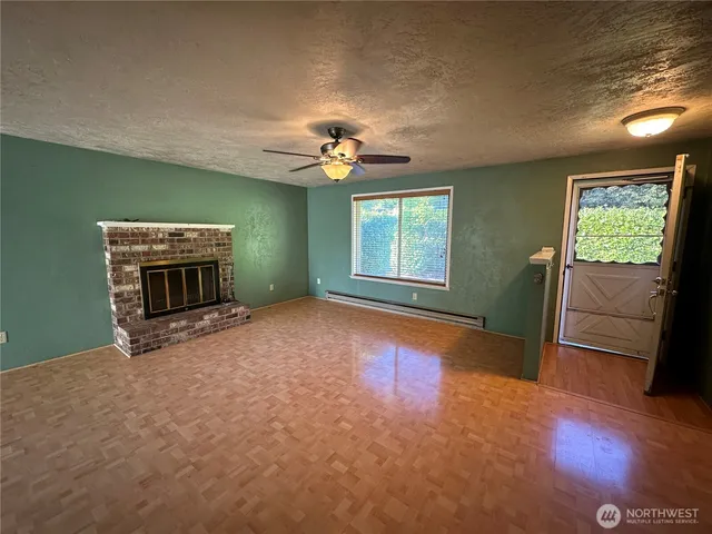 a view of an empty room with a fireplace and a window