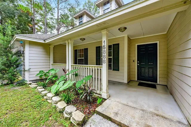 a bedroom with a bed painting on wall and a large window