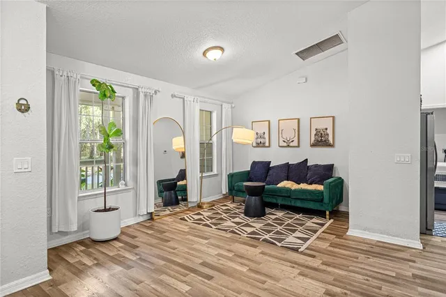 a living room with furniture and a wooden floor