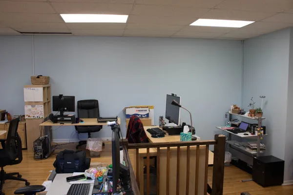 a view of a workspace with furniture and a window