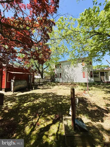 a backyard of a house with table and chairs under an umbrella