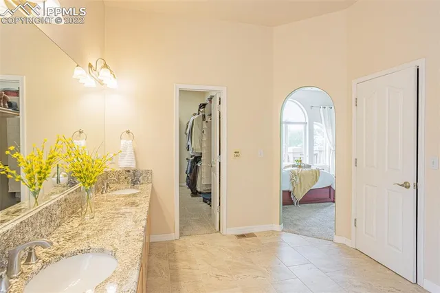 a bathroom with a granite countertop sink a toilet a mirror a bathtub and shower