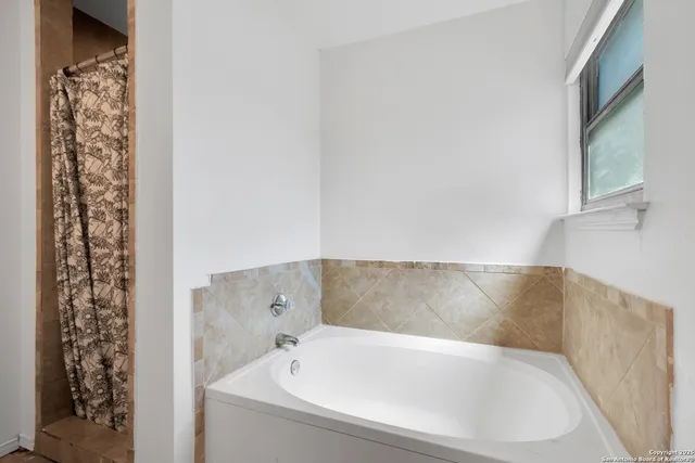 a bathroom with bathtub and shower