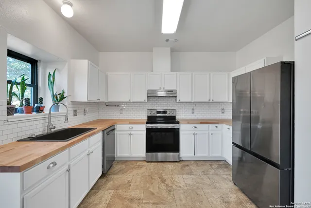 a kitchen with stainless steel appliances granite countertop a refrigerator sink and stove