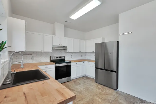 a kitchen with a refrigerator sink and stainless steel appliances