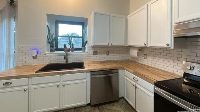 a kitchen with appliances a sink and cabinets