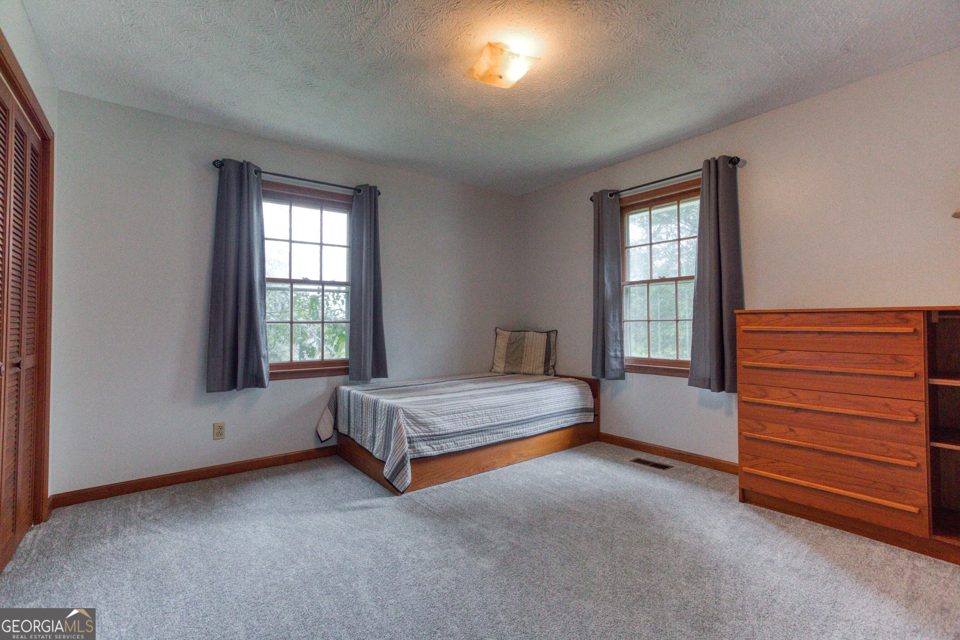 2141 Greensboro Road Madison, GA 30650 - Photo 31 of 35 a spacious bedroom with a bed and a window