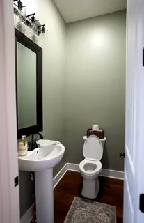 a bathroom with a sink toilet and a mirror