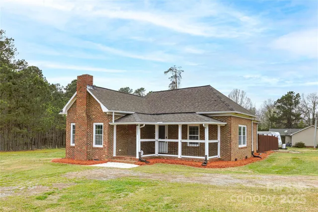 a view of a house with a yard and sitting area