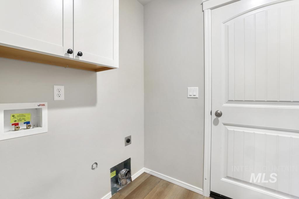 1113 Meadow Lake Loop Buhl, ID 83316 - Photo 14 of 27 Laundry area featuring light wood-style floors, hookup for a washing machine, cabinet space, hookup for an electric dryer, and hookup for a gas dryer