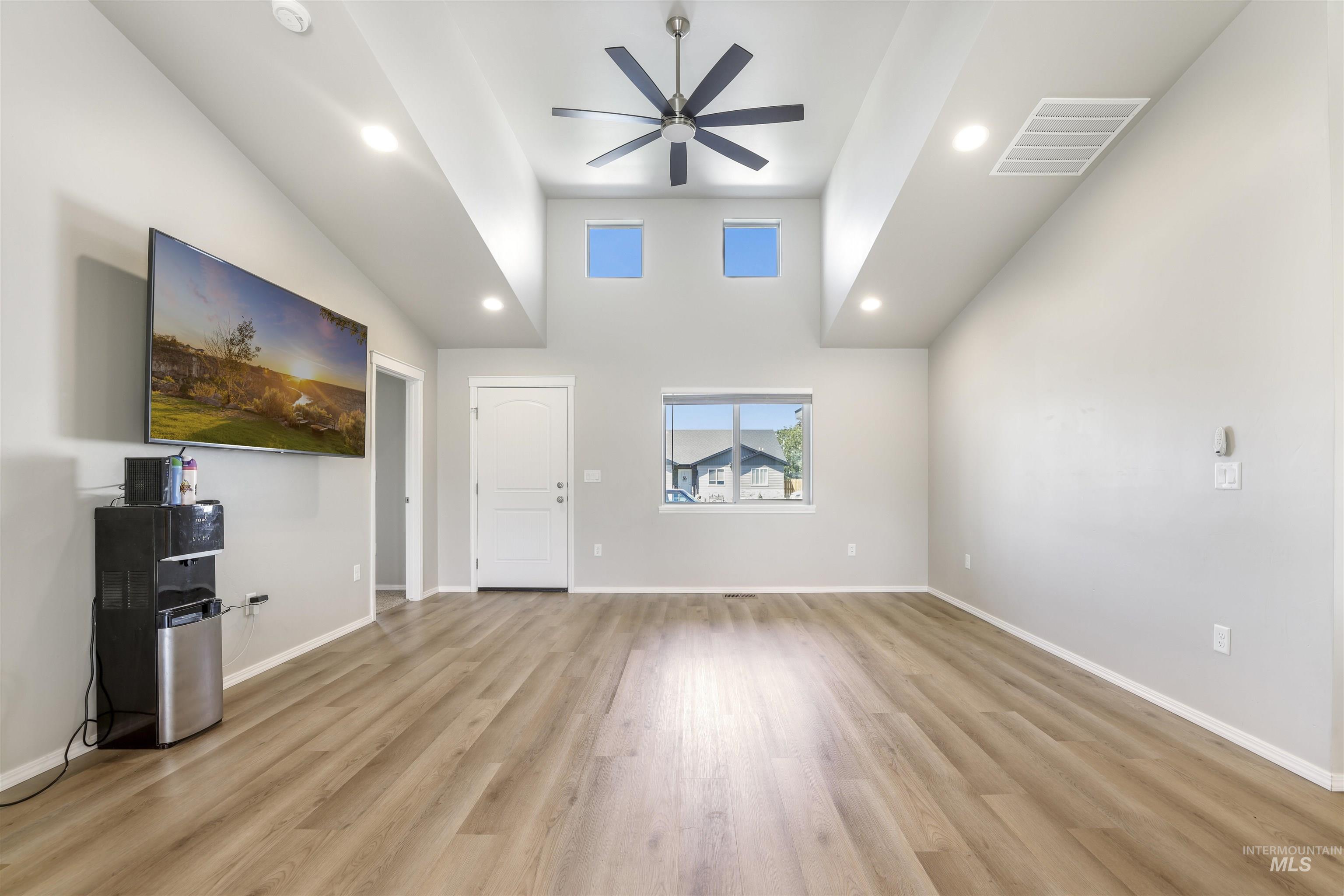 1113 Meadow Lake Loop Buhl, ID 83316 - Photo 6 of 15 Unfurnished living room with recessed lighting, light wood finished floors, a high ceiling, and a ceiling fan