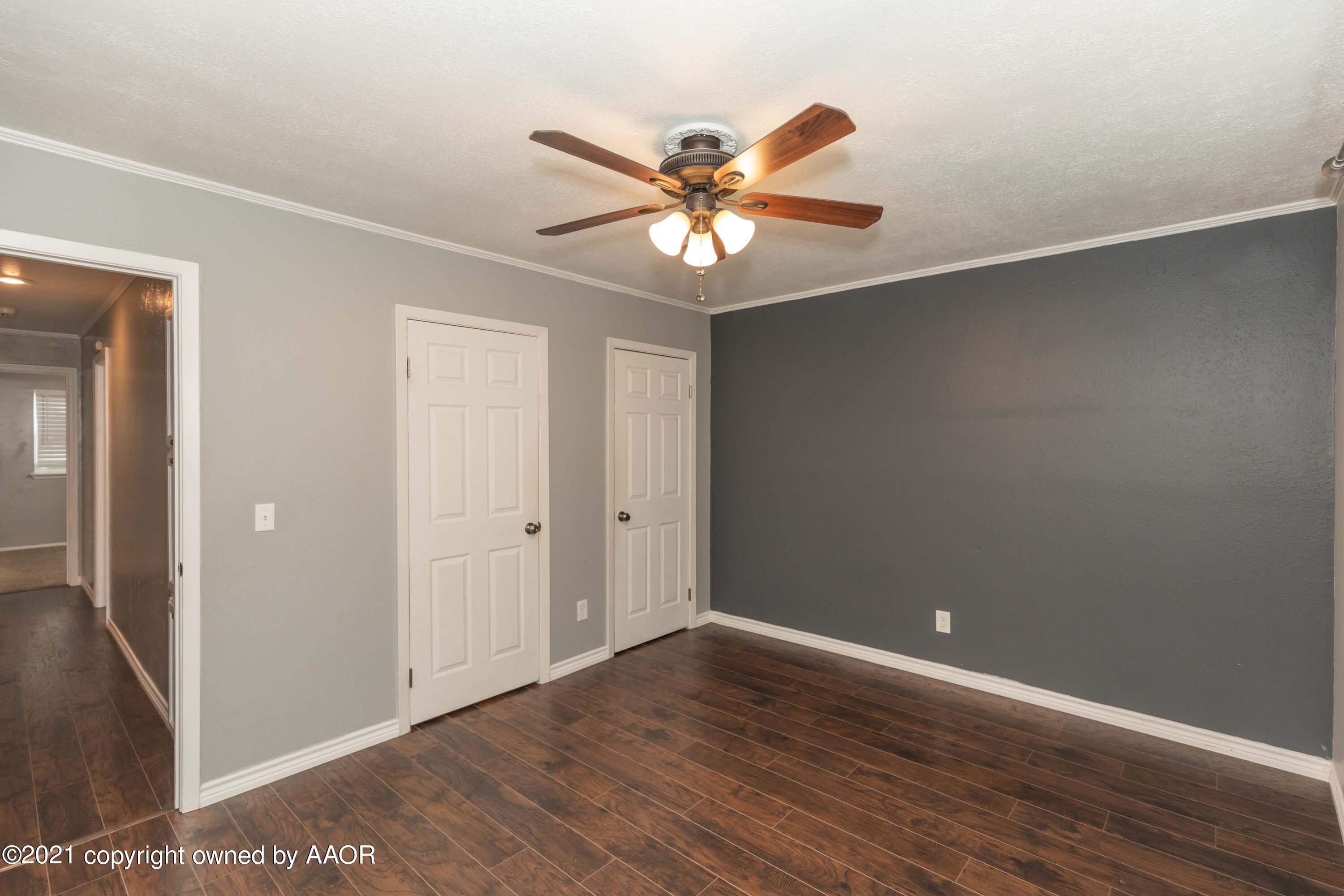 5142 McCarty Boulevard Amarillo, TX 79110 - Photo 20 of 38 a view of an empty room with wooden floor and a ceiling fan