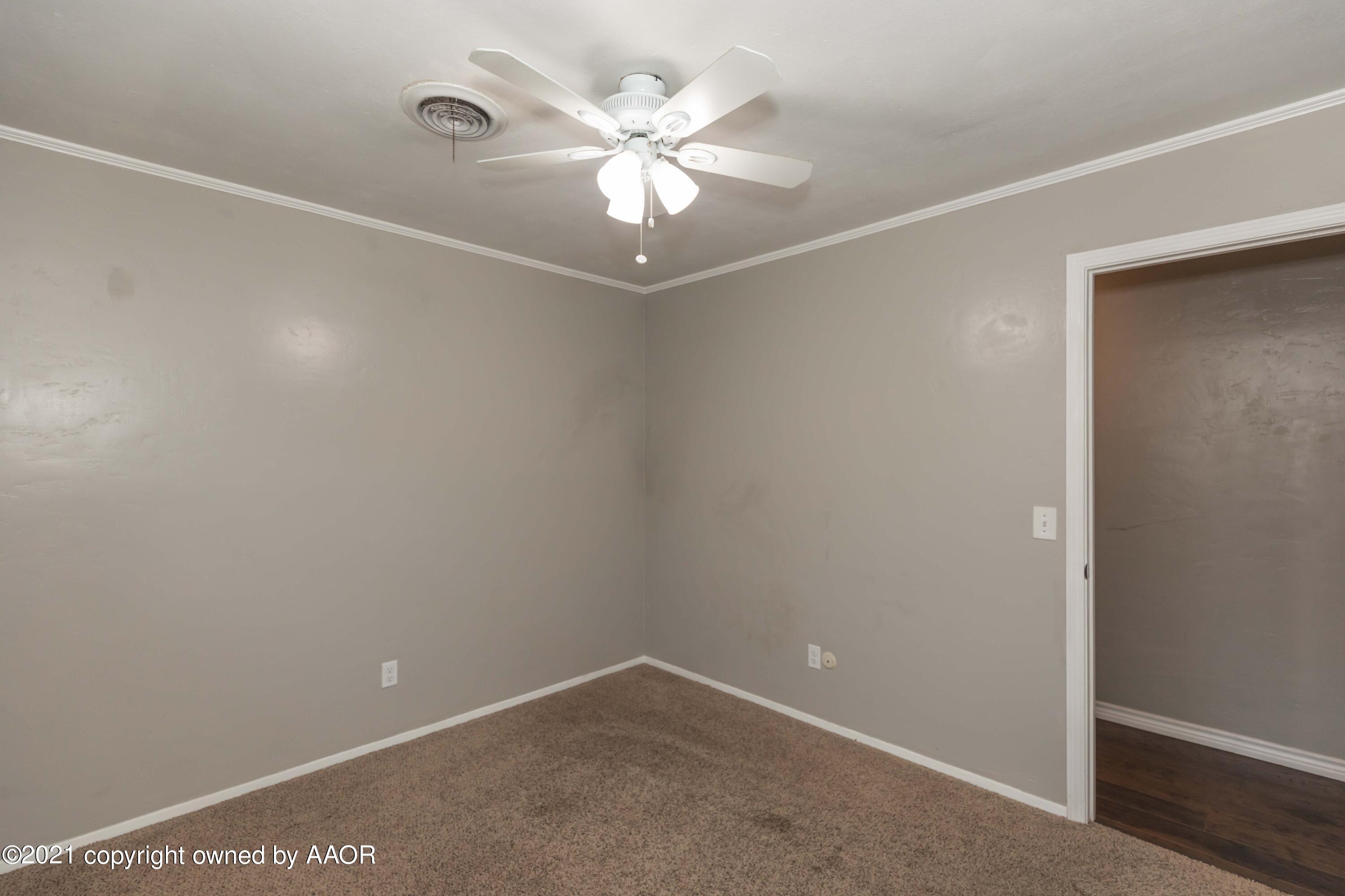 5142 McCarty Boulevard Amarillo, TX 79110 - Photo 26 of 38 an empty room with a chandelier fan and windows