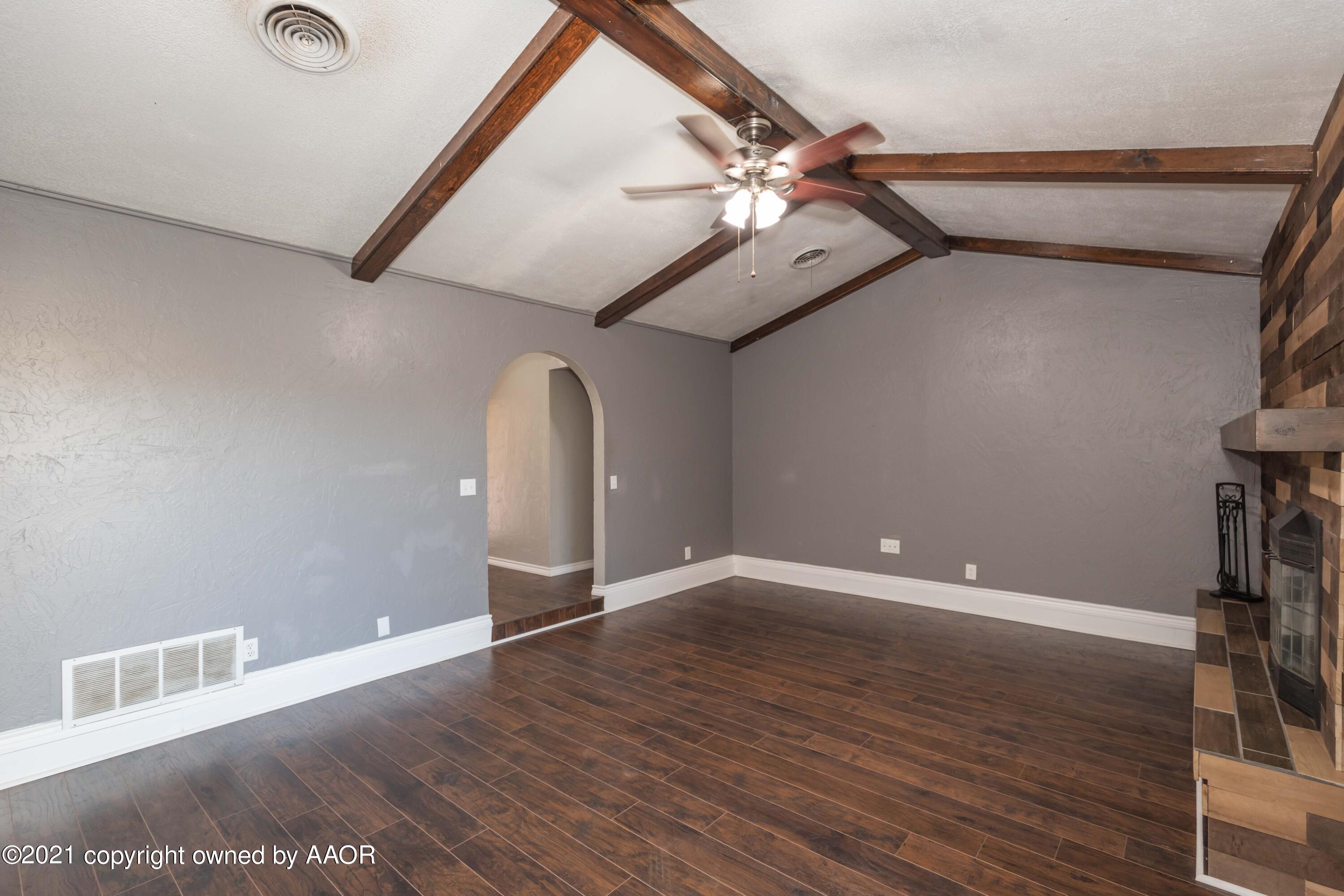 5142 McCarty Boulevard Amarillo, TX 79110 - Photo 5 of 38 a view of an empty room with wooden floor and a ceiling fan