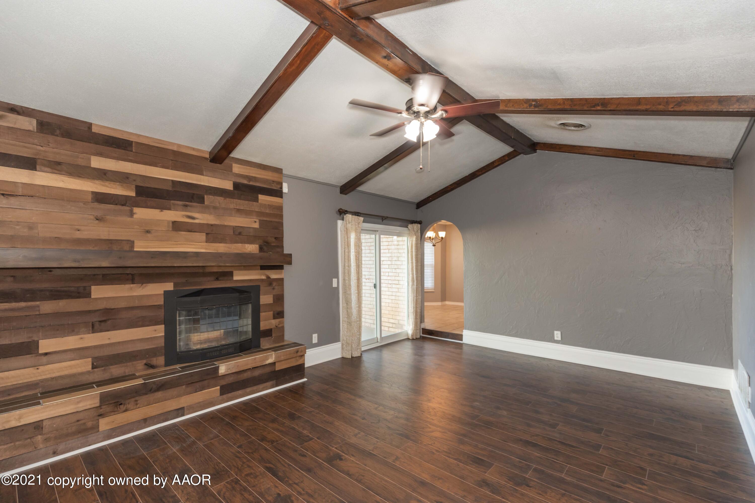 5142 McCarty Boulevard Amarillo, TX 79110 - Photo 8 of 38 a view of an empty room with a fireplace and wooden floor