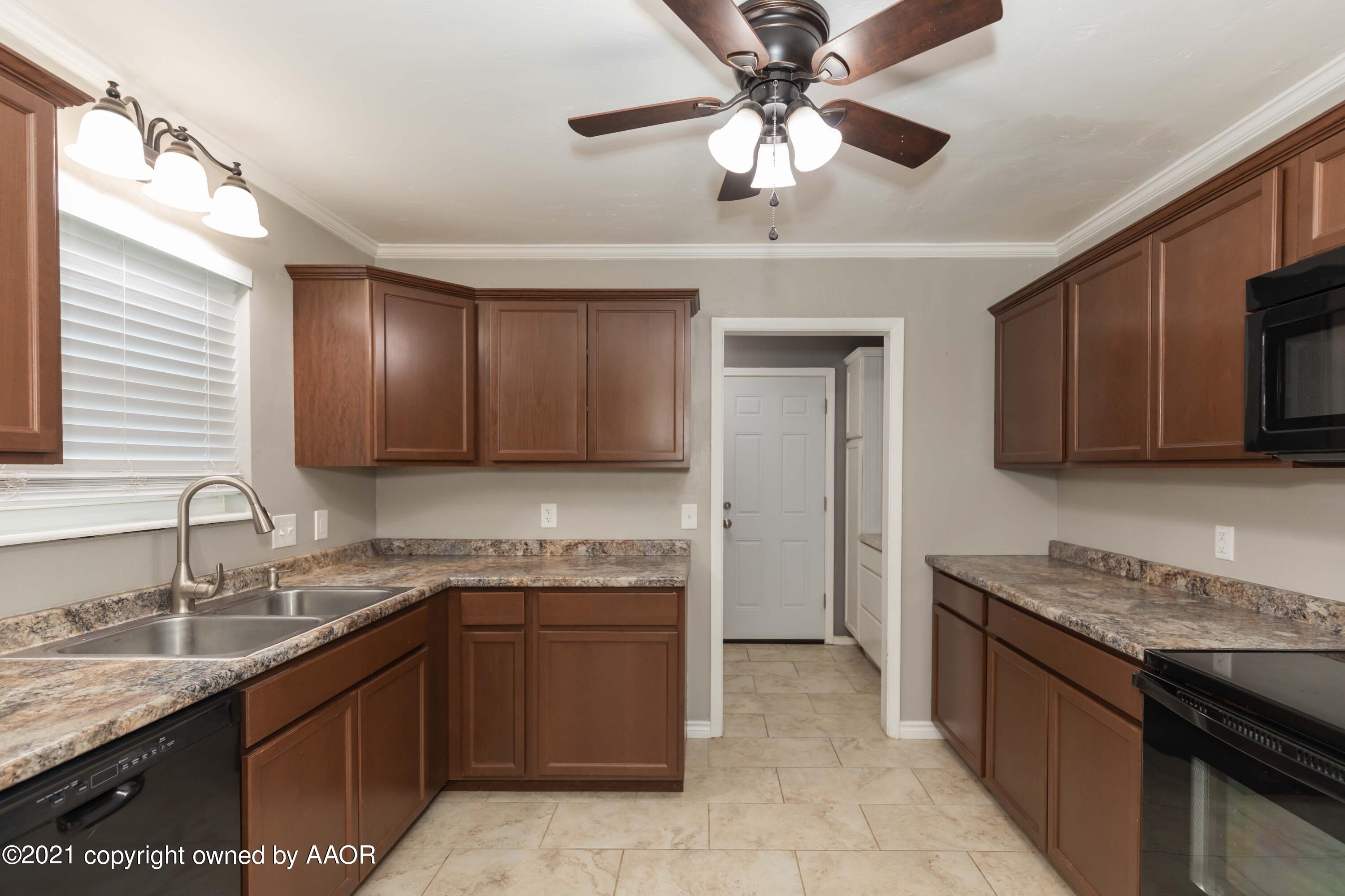 5142 McCarty Boulevard Amarillo, TX 79110 - Photo 10 of 38 a kitchen with a sink a stove cabinets and a refrigerator