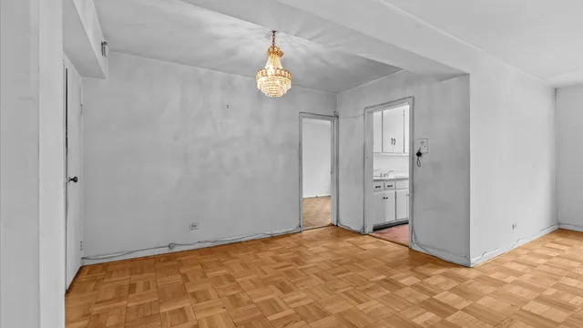 a view of a room with wooden floor and white walls