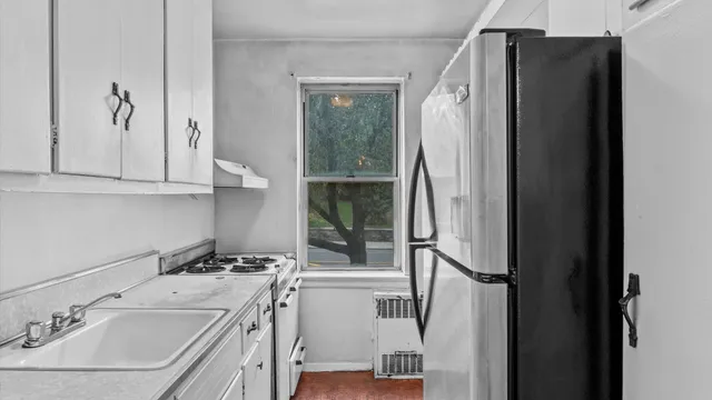 a kitchen with a refrigerator sink and cabinets