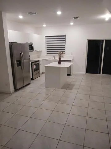 a kitchen with stainless steel appliances a refrigerator sink and microwave