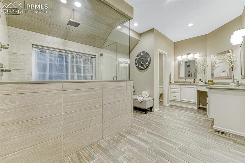 15585 Falcon Ridge Court Colorado Springs, CO 80921 - Photo 23 of 50 a bathroom with a sink a large mirror and a shower