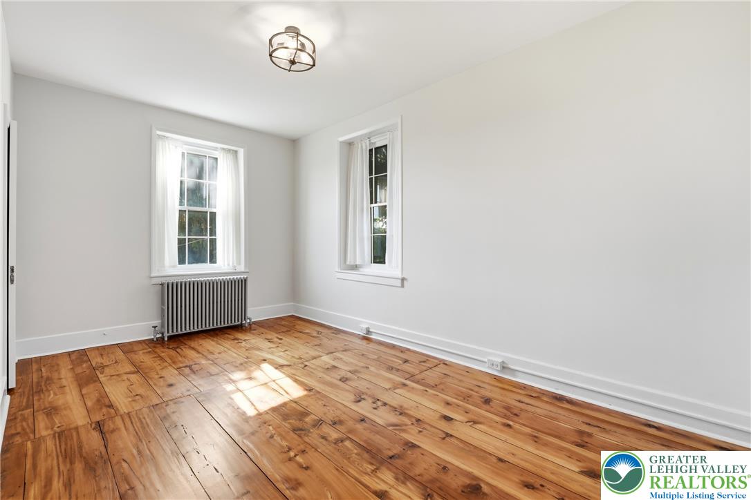 4682 Steuben Road Bethlehem, PA 18020 - Photo 29 of 79 Natural light streams into this room, highlighting the warm, wide-plank wood flooring.