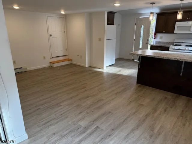 an empty room with wooden floor and a sink