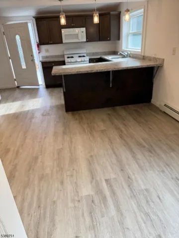 a room with kitchen island stainless steel appliances a sink stove and microwave